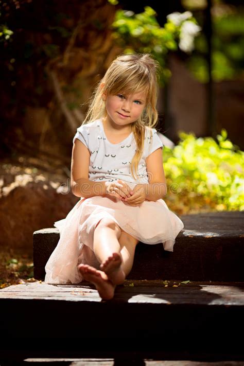 A Four Year Old Girl Sits On A Wooden Staircase Stock Image Image Of