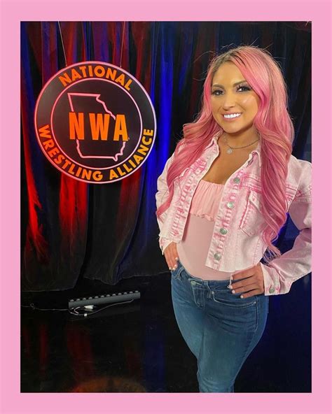 A Woman With Pink Hair Standing In Front Of A National Wrestling