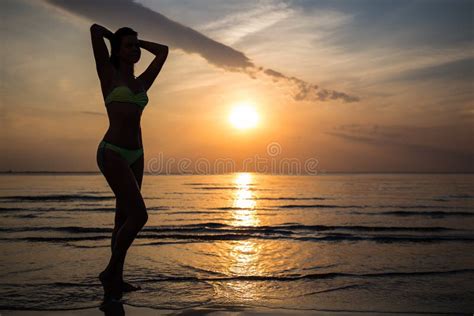 Silhouette Of Woman In Bikini Posing On Beach At Sunset Stock Image