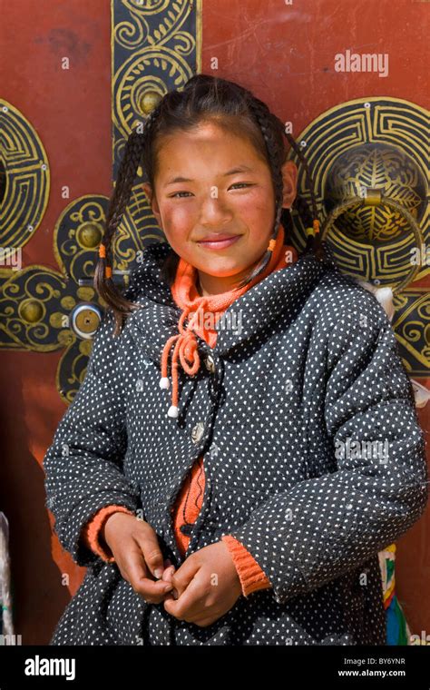 Tibetan Girl In Front Of Entrance To House In Tibetan Village On The