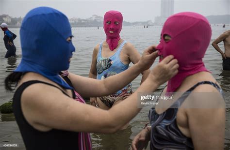 A Chinese Woman Adjusts Anothers Face Kini As They Swim On August