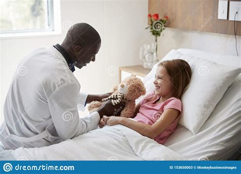 Male Doctor Visiting Girl Lying In Hospital Bed Hugging Teddy Bear Stock Image Image Of