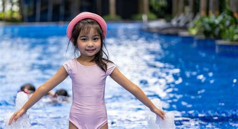 Portrait Of Pretty Asian Child Smilling And Posing On Swimming Pool