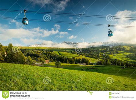 Aerial Tram Cable Car Going Up During Sunset With Green Grass Stock