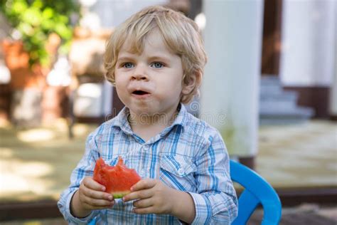 Adorable Little Toddler Boy With Blond Hairs Eating Watermelon I Stock