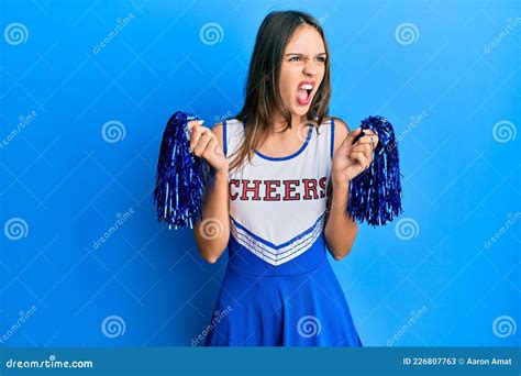 Young Brunette Woman Wearing Cheerleader Uniform Angry And Mad Screaming Frustrated And Furious