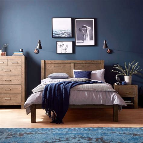 A sea blue rug and white walls and beams create a light and airy feel in this bedroom. The Corniche bedroom range is crafted from dark American ...