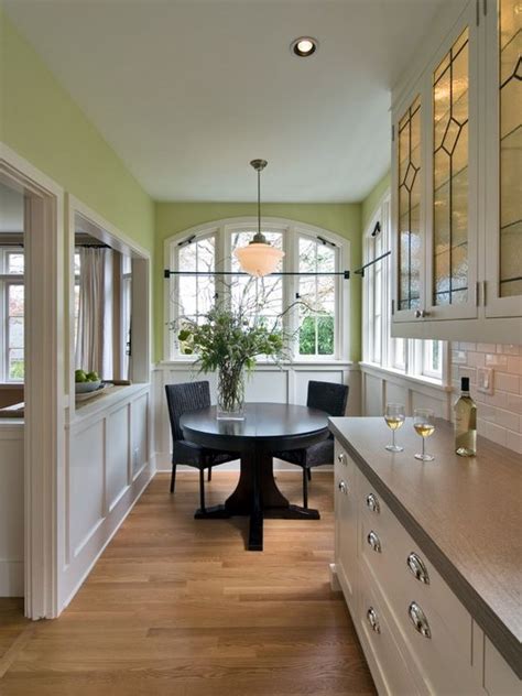 Give your kitchen a makeover by painting your cabinets. Traditional eat-in kitchen idea in Portland with glass-front cabinets and white cabinets ...