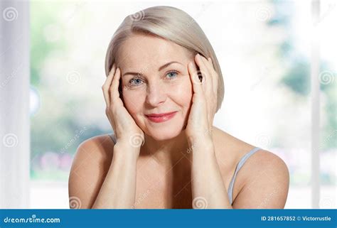 Happy Beautiful Middle Aged Blonde Woman Shows Off Her Perfectly Well Groomed Face And Sitting