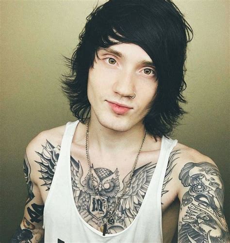 a man with black hair and tattoos on his chest wearing a tank top that says the clash