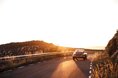 Spain Classic Car Driving On Road During Sunset Stock Photo