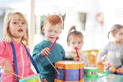 Young children playing with musical instruments - Stock Photo - Dissolve