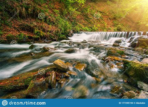 Waterfall On Mountain River In Autumn Forest Under Bright Sun Stock