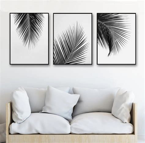 Three Black And White Paintings On The Wall Above A Couch