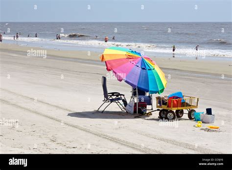 Sunbathers And Colorful Beach Umbrella On The Public Beach At Jekyll