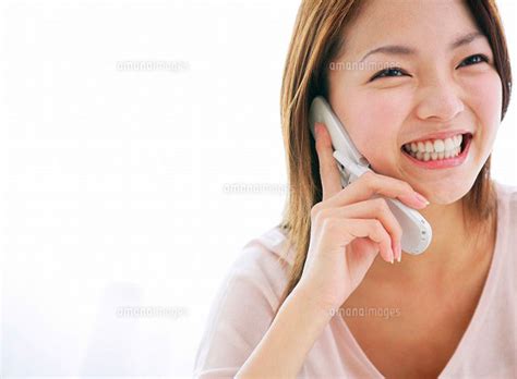 携帯電話で話しをする日本人女性[11004023349]の写真素材・イラスト素材｜アマナイメージズ