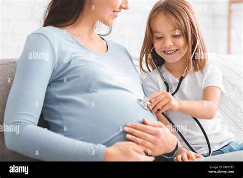Little Girl Playing Doctor With Her Pregnant Mother Stock Photo Alamy