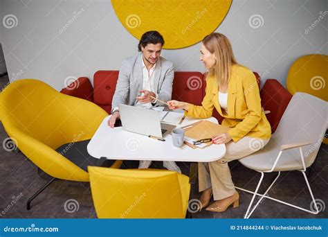 Two Friendly People Having Pleasant Conversation In Office Stock Photo