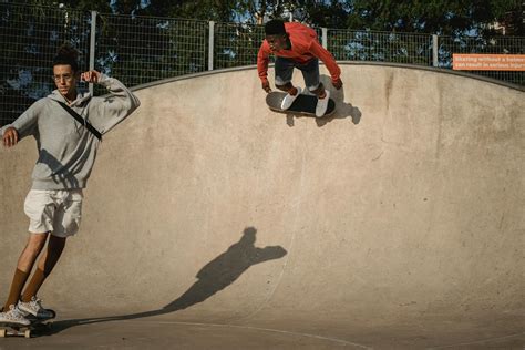Professional Multiethnic Male Skateboarders Practicing Tricks On Ramp