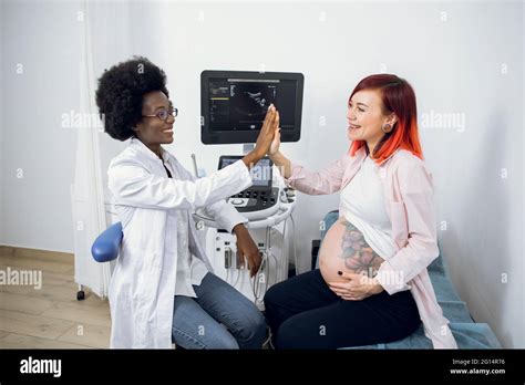 Happy Attractive Pregnant Caucasian Woman Patient Giving Her Smiling African Female Obstetrician