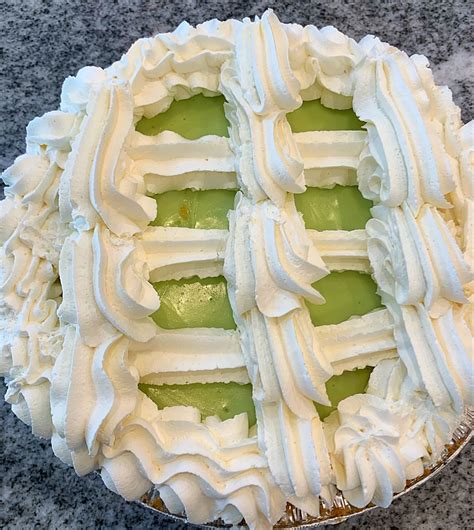A Pie With White Frosting And Cucumber Slices On Top