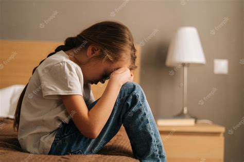 Premium Photo Side View Of Sad Little Girl Hugging Knee Sobbing With