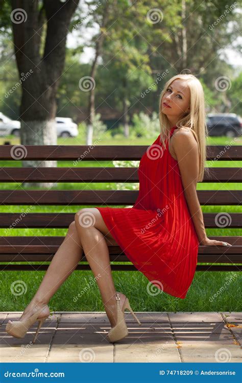 Mujer Hermosa Joven Que Se Sienta En Un Banco En El Parque Del Verano Imagen De Archivo Imagen