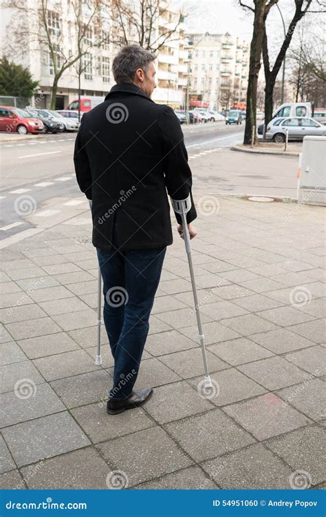 Man Walking On Street Using Crutches Stock Photo Image Of Outdoors