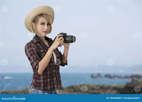 Tourist Girl Holding Camera In Hand With Blue Sky And Sea On Bac Stock