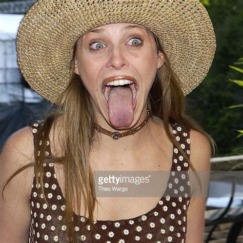 a woman with her tongue out and wearing a straw hat