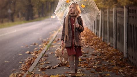 Cute Little Girl Is Walking On Pavement With Dry Leaves Holding Umbrella Wearing Muffler And ...
