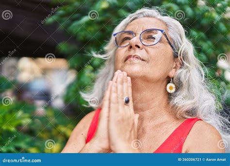 Middle Age Grey Haired Woman Praying With Closed Eyes At Park Stock