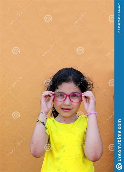 Hispanic 6 Year Old Girl Shows Her Red Glasses That She Wears Because She Has Astigmatism And