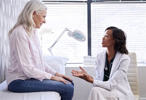 mature woman in consultation with female doctor sitting on examination couch in office vegas