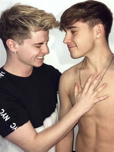 Two Babe Men Standing Next To Each Other With Their Arms Around One