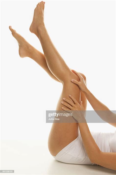 Low Section Of Sensuous Woman Touching Leg Over White Background High