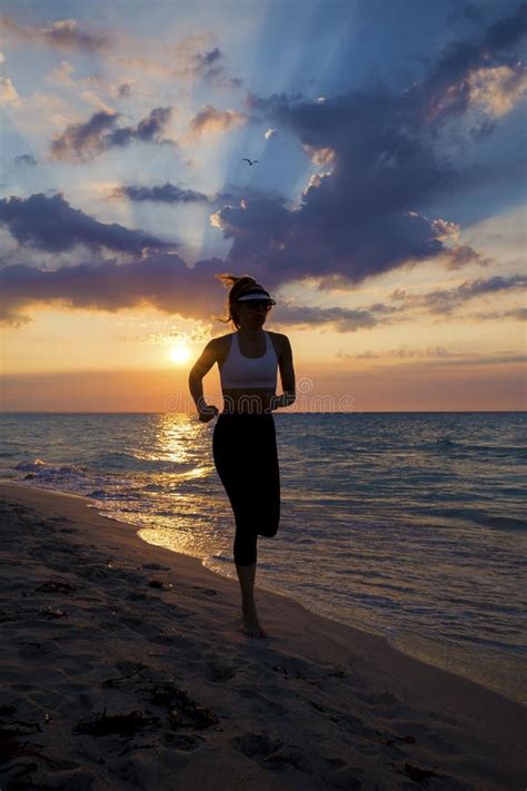 Vrouw Die Op Het Strand Tijdens Zonsondergang Lopen Stock Afbeelding