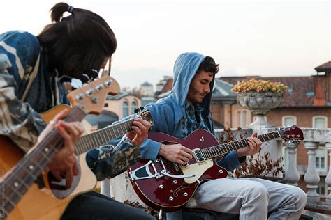 Two Young Men Playing Music Outdoors By Stocksy Contributor Luca Di