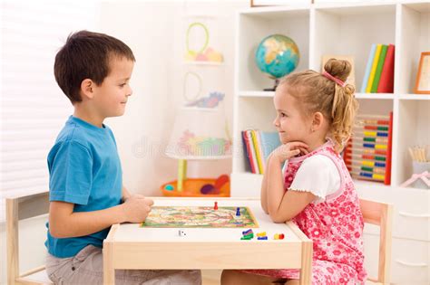 Kids Playing Board Game In Their Room Stock Photo Image Of Sitting