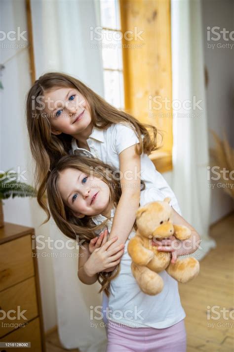 Adorable Twin Sisters Hugging At Home Stock Photo Stock Photo