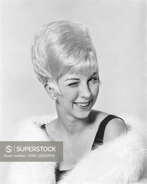 1960s portrait blonde woman bouffant hairdo winking wearing fur stole superstock