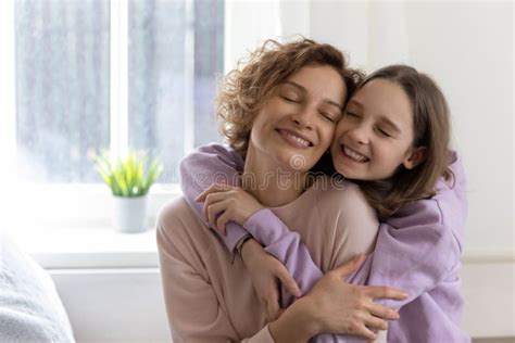 Happy Teenage Daughter Hug Mom Showing Love And Care Stock Photo