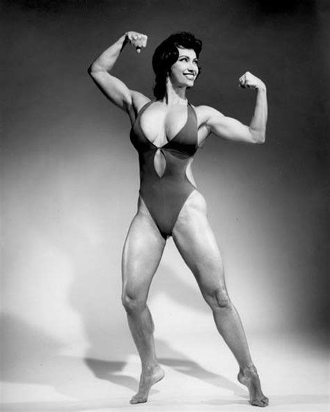 A Woman In A Bodysuit Flexing Her Muscles With One Arm And Two Hands