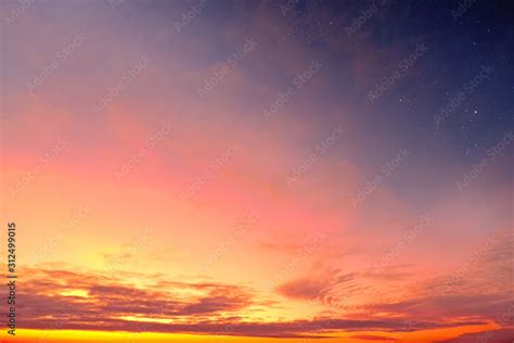 Orange Sky At Sunset And Red Clouds Landscape Against Bright Star On