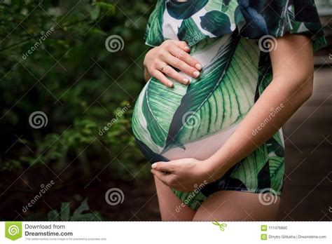 Belly Of Young Pregnant Caucasian Woman In Swimsuit At Greenery Stock
