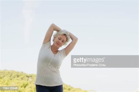 Mature Woman Stretching With Eyes Closed Photo Getty Images