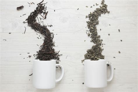 Smash, when the cup fell off the table. Two types of dry tea leaves falling from cup over white ...