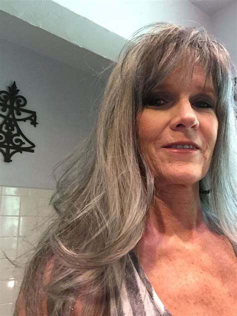 an older woman with long gray hair is taking a selfie