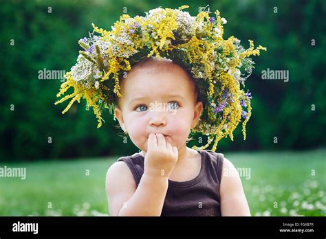 Beautiful Happy Little Baby Girl In A Wreath On A Meadow On The Nature