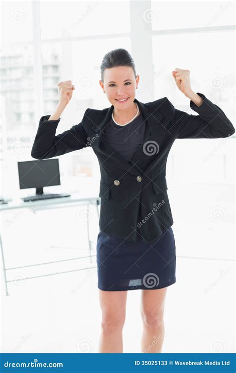 Elegant And Happy Businesswoman Clenching Fists In Office Stock Image